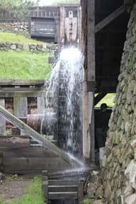 Photo shows water spilling as it drives a water wheel at an old blacksmithing shop in Massachusetts.