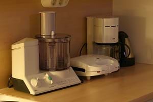 A variety of electrical kitchen appliances that inlcude a mixer, a coffee maker and a sandwich maker.