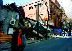A photograph shows a collapsed multi-story building.