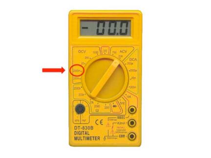 Digital multimeter with an arrow pointing to the 2000mV (DC) notch on the dial.