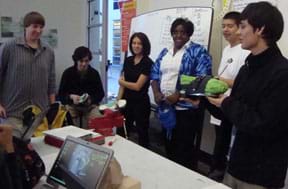 Photo shows six students at the front of a class with their varied shoe prototypes.