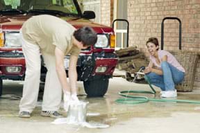 Photo shows two people washing a car.