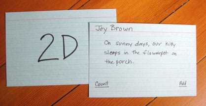 A photograph shows two index cards, one with "2D" written on it and the other with: Joy Brown; On sunny days, our kitty sleeps in the flowerpot on the porch; Count; Add.