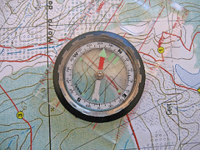 A compass resting on top of a map.