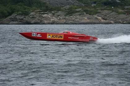 A photo shows a red speed boat skimming very fast across the water.