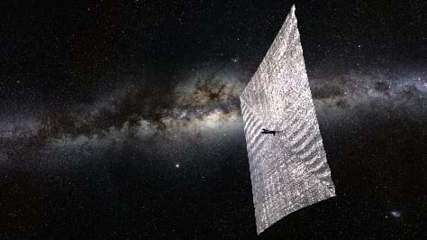 A reflective square sail pushes a cube satellite through the blackness of space as light reflects off of the sail’s silvery surface.