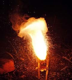 A photograph shows sparks flying off globules of molten iron, leaving smoke behind.