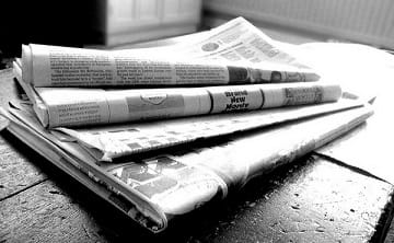 A stack of black and white newspapers. 
