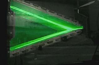 Photo shows a sheet of laser light illuminating the surfaces of a heat exchanger during an experiment.