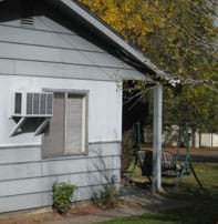 Photo shows the side of a house with a ventilated 2 x 3-foot box mounted to the exterior wall next to a window.