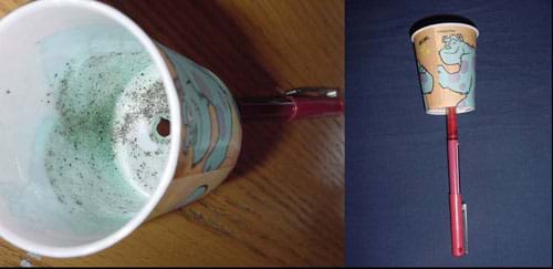 Two photos: 1) Side view of a paper cup with a pen stuck through its base. 2) View of the inside of the cup, with smeared petroleum jelly and black pepper flecks.