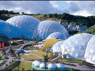 Landscape photo shows cluster of community buildings including geodesic greenhouse domes.