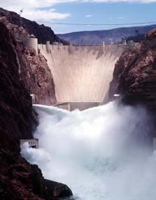 A photograph shows a huge concrete dam and water spraying below it.
