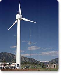 A photograph shows a very tall white three-blade wind turbine at the National Wind Technology Center outside of Boulder, CO.