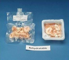 Photo shows two different packages of rehydratable shrimp cocktail. The package on the left is clear and vacuum sealed, and has a short tube placed in the side for adding water. The package on the right is a translucent plastic square box, with the lid removed. A sign below the packages reads: "Rehydratable." 