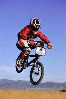 A photograph of a BMX bike in the air. Its lightweight construction allows BMX racers to achieve great height when jumping during competition.