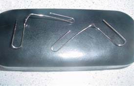 A photo shows two bent paperclips with the two curved ends pulled away from each other at right angles. 