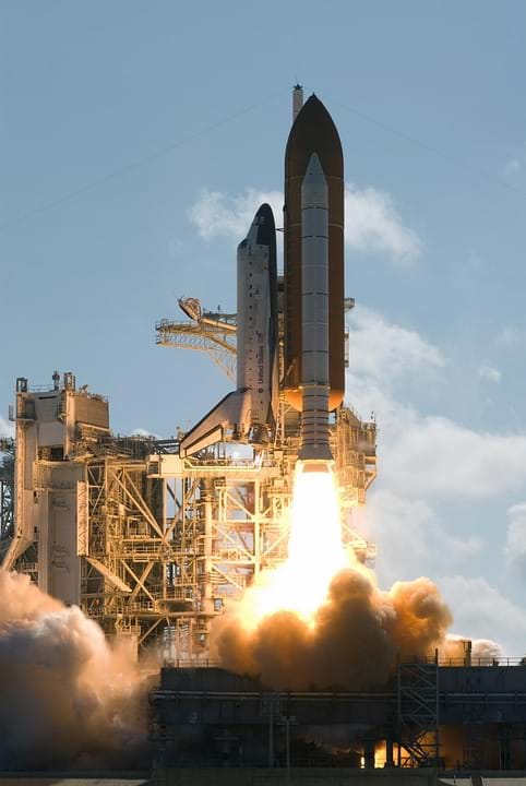 Photo shows a US space shuttle lifting off with much fire and smoke seen below the rocket.