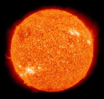Photo shows the sun with solar flares erupting from the surface.
