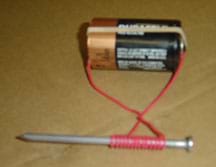 A photograph shows the wire ends secured to the battery with a rubber band.