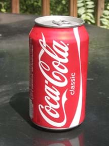 Photo shows a pop-top aluminum can of Coca-Cola.