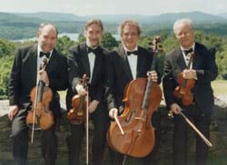 Four men in tuxedos hold various stringed instruents and bows.