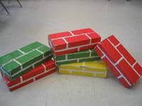 Photo of six shoe-box sized cardboard classroom building blocks.