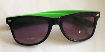 A photograph shows a pair of dark sunglasses with black and green frames.