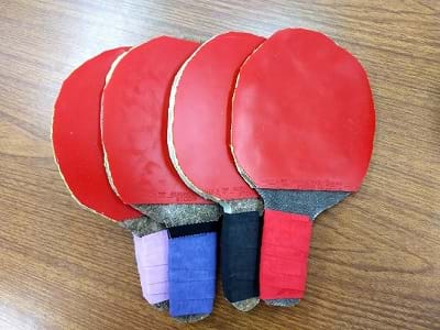 Four biocomposite ping-pong paddle prototypes lay on a table. 