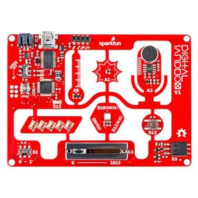 The product image of a digital sandbox microcontroller. The rectangular red board has smaller processors scattered on it, and the text “digital sandbox” is written in white on the top right corner. 