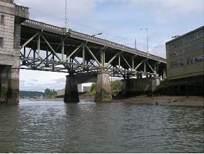 Photo shows a deck bridge, with large trusses below the bridge.