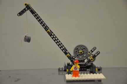 Photo shows a construction crane built of LEGO pieces with a LEGO construction worker.