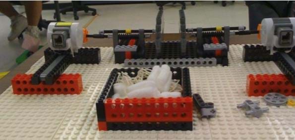 A photograph shows a LEGO raised-dots platform composed of various LEGO bricks, compressors and motors.
