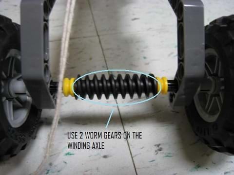 Photo shows a screw-shaped bar between two wheels with the note: Mount two worm hears on the winding/driving axle.