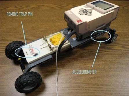 Photo of a mouse trap race car shows the brick and accelerometer over the back wheels, and the mousetrap pin removed.