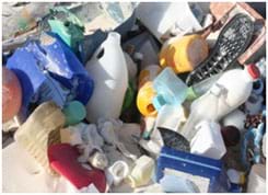 A photograph shows a pile of many different types of plastics found in a garbage dump: beverage, liquid and food containers and their caps and lids, shoe soles, buckets.