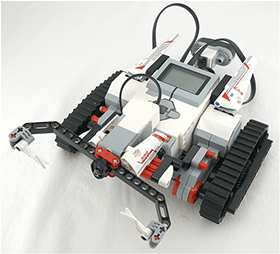 An image of a two-wheeled EV3 robot pushing a water bottle across a surface.