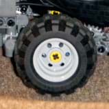 Photo shows a toy wheel made from a flexible black treaded plastic tire and a hard grey plastic rim. 