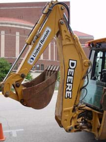 Photo shows a backhoe boom, dipper stick and bucket.