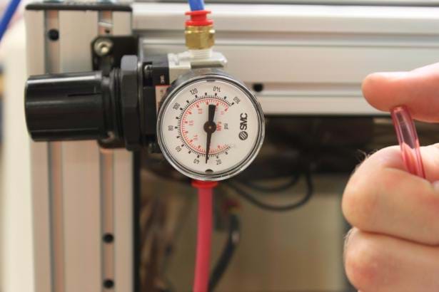 Photo shows a pressure gauge reading 30 psi and showing thumb over hose end.