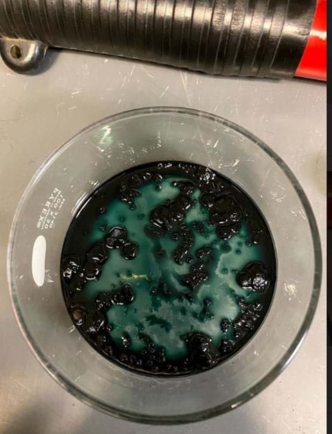 A photo shows liquid solution in a new beaker and seed crystals at the bottom of the beaker. 