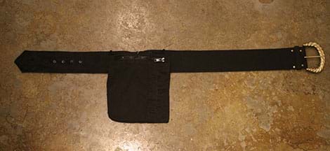 A photograph shows a square black pocket that was cut out of a jacket and sewn onto the middle section of a black belt with buckle and holes.