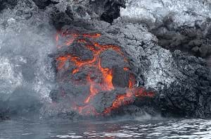 A lava flow cools along the shoreline and releases steam into the air on the Yemeni island of Jabal at-Tair.