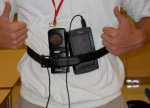 A photograph shows the activity's data collection setup, two palm-sized devices with cords (motion detector, accelerometer), both attached via belt to the middle front chest area of a teen. 