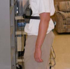 A photograph shows the same student as in Figure 1, viewed from the side, as he, and his strapped-on sensors, faces a wall/barrier.