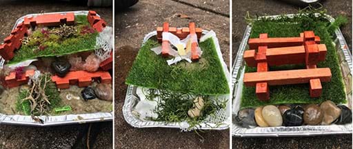 An image of student teams’ designs using the provided materials: toy logs, rocks, moss, an aluminum pan, and sand.