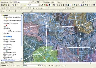 An image from ESRI's ArcGIS® software with a table of contents on the left that gives layers that can be turned on and off, a top screen space that has many different icons for GIS manipulation tools, and a main screen on the right and center that displays aerial photos and GIS layers on top of them.
