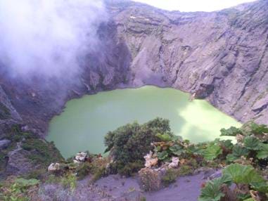 Photo shows a muddy green lake surrounded by steep rocky banks.