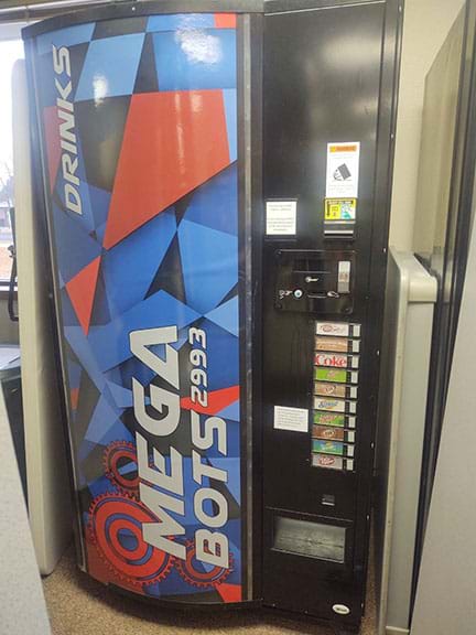 A photo of a vending machine with front graphics that say “MEGABOTS 2993”.