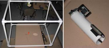 Two photos: (left) A cube shape made with PVC pipes, a round mirror attached to one edge, and a small, orange-haired troll inside. (right) A white tube with a laser pointer and metal box attached to one side.